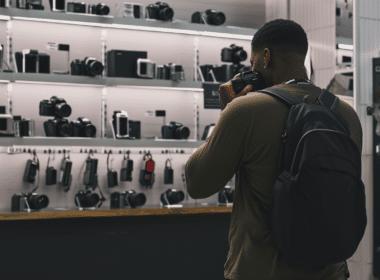 Homme hésitant sur le nombre de pixel à prendre pour son appareil photo dans un magasin